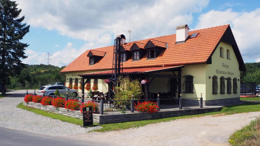 een gebouw met een oranje dak op een straat bij Restaurace a pension Chalupa in Hlásná Třebaň