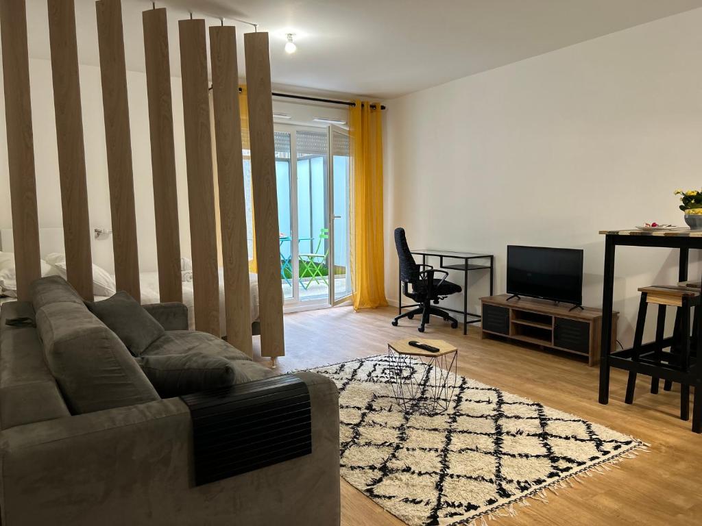 a living room with a couch and a television at Le Vestige - Between Paris & DisneyLand - 5min From Train Station in Villiers-sur-Marne