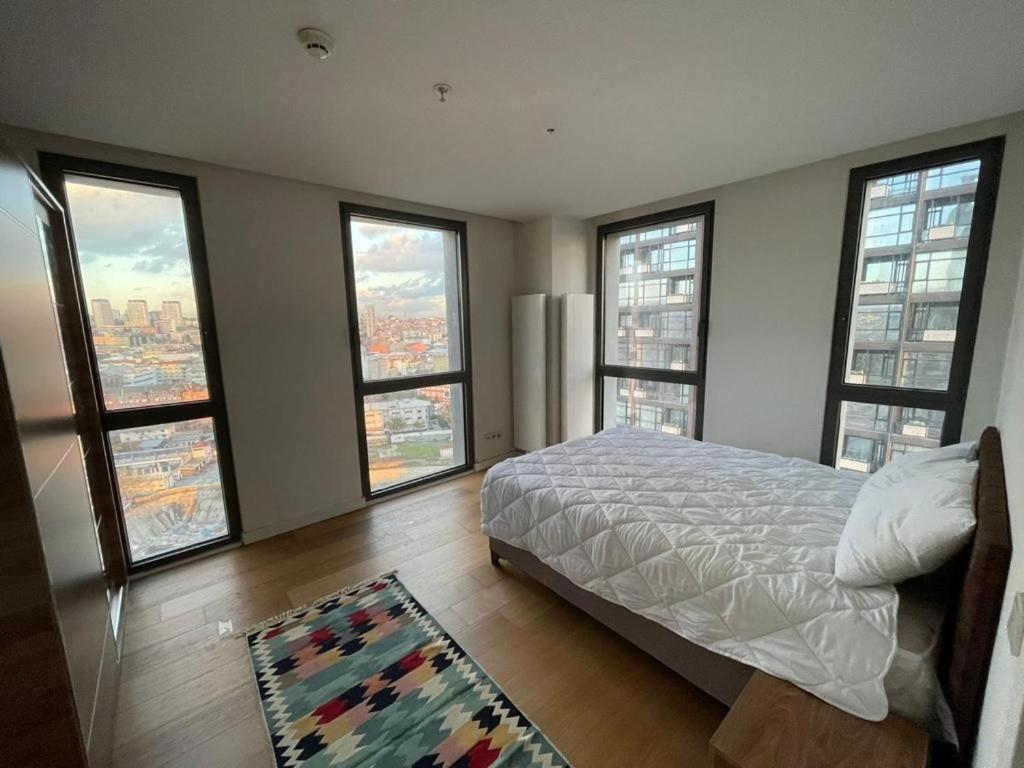 una camera da letto con ampie finestre, un letto e un tappeto di Fully equipped house within a serviced compound a Istanbul
