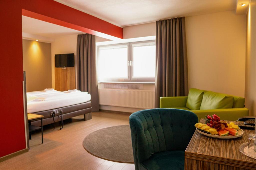 un soggiorno con letto, divano e tavolo di Hotel Sportforum a Rostock