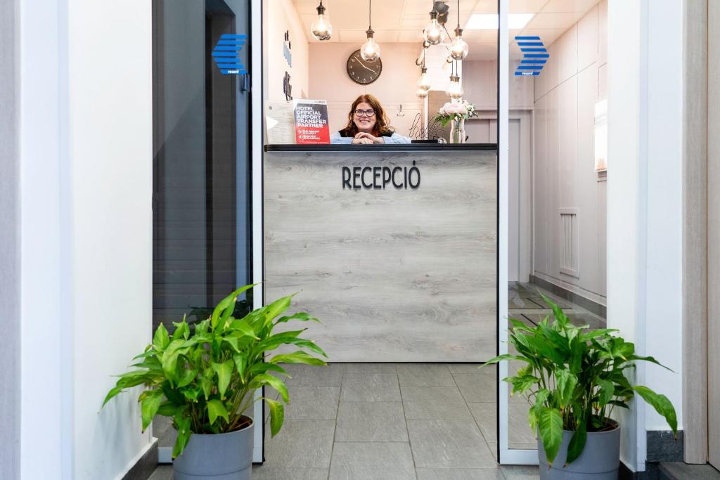 a woman is standing behind a mirror in a store at Hotel Metro in Budapest