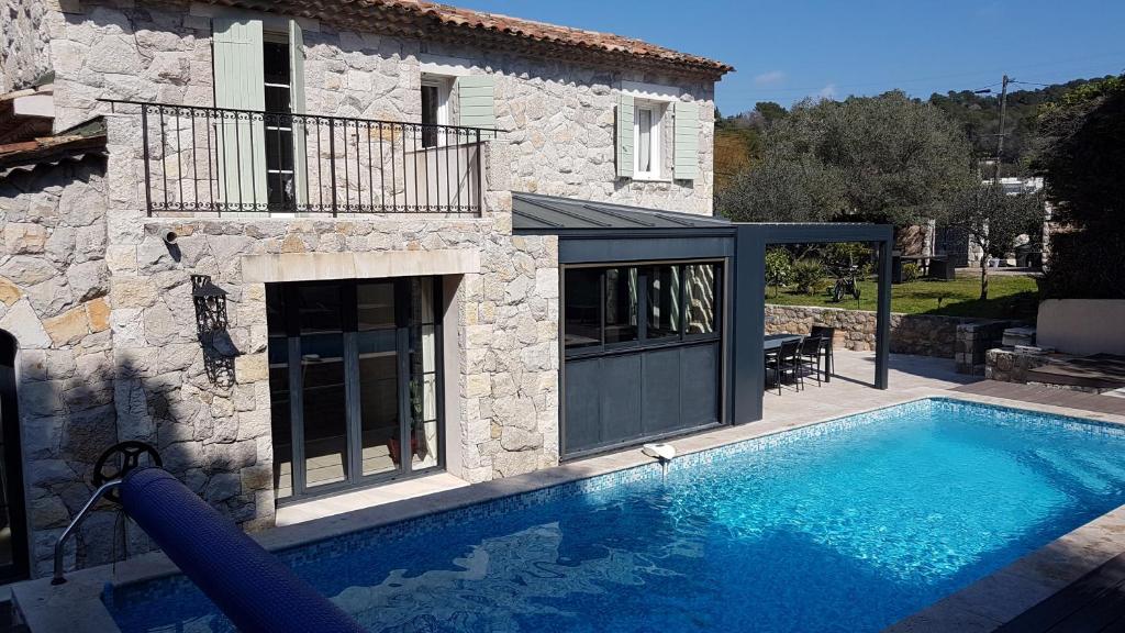 a house with a swimming pool in front of a house at Mougins limite Cannes Magnifique Mas vue sur le village historique de Mougins in Mougins