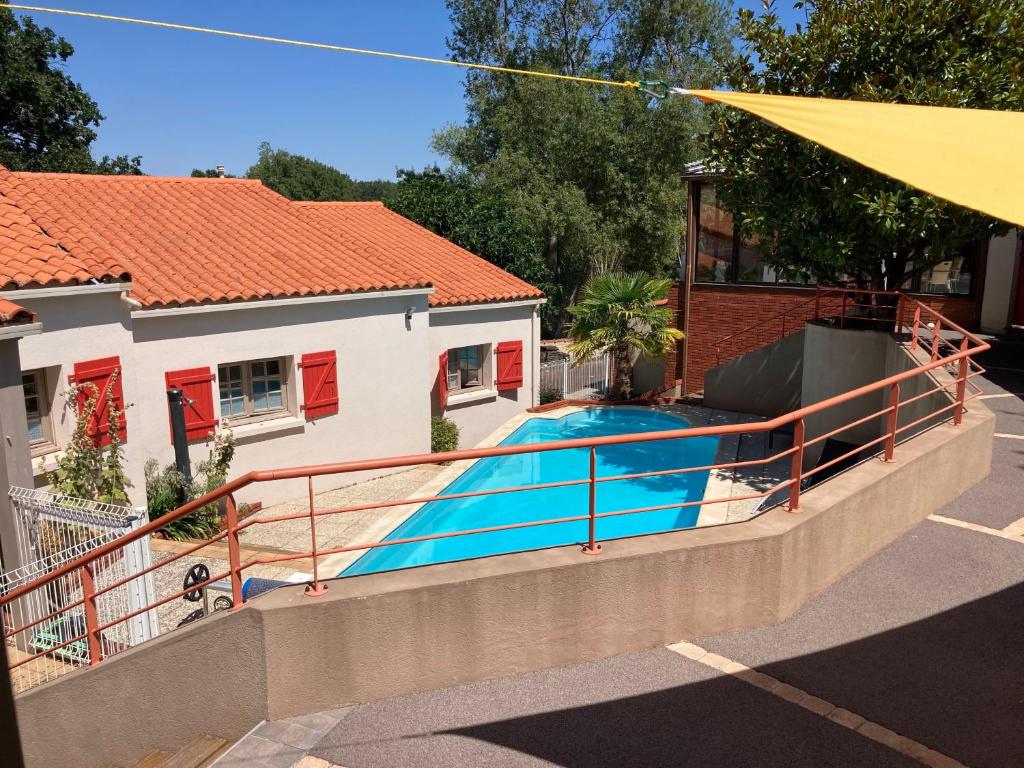 - une piscine à côté d'une maison avec une clôture dans l'établissement Le Patio de la Madone, à Le Givre