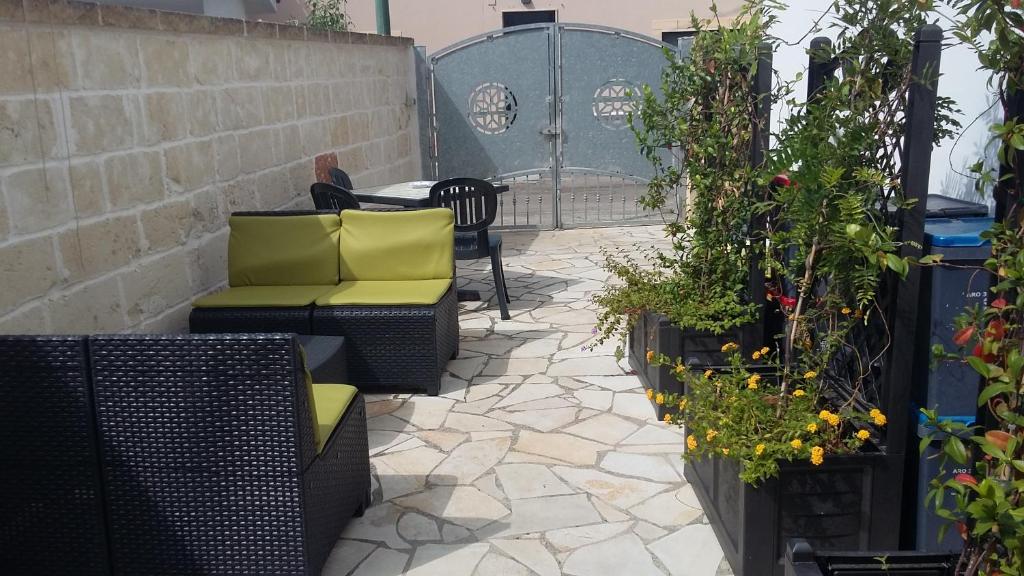 un patio con sillas, una mesa y algunas plantas en mini Residence Samarcanda appartamenti en Porto Cesareo