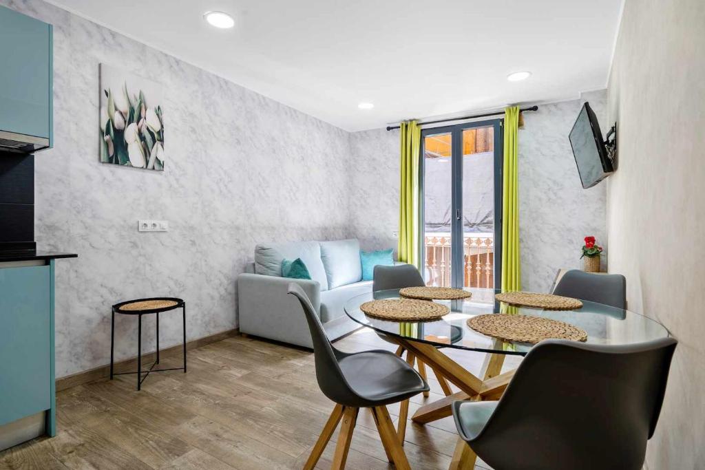 een woonkamer met een tafel en stoelen en een bank bij Apartments Lilia Reus in Reus