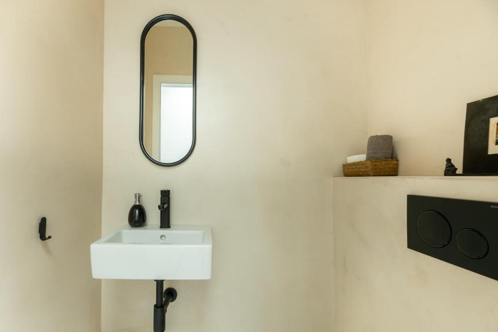 a bathroom with a white sink and a mirror at Casa Juliarina in Sant Josep de sa Talaia