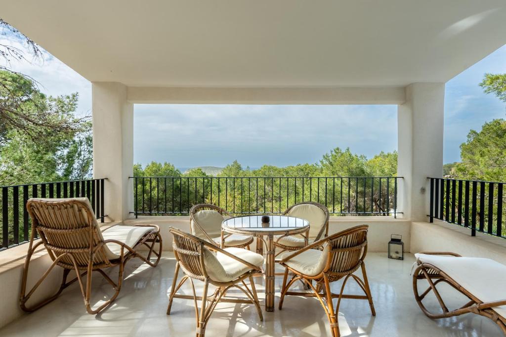 Un patio con sillas y una mesa en el balcón. en Casa Juliarina en San Jose de sa Talaia