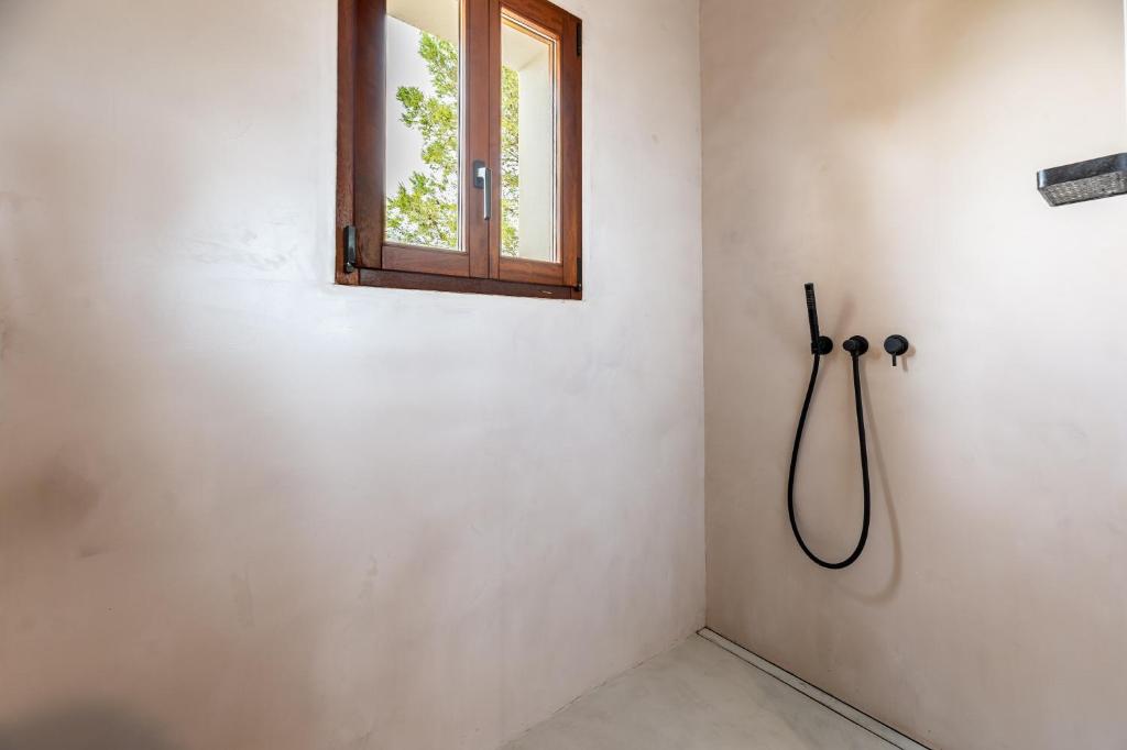 a shower in a bathroom with a window at Casa Juliarina in Sant Josep de sa Talaia