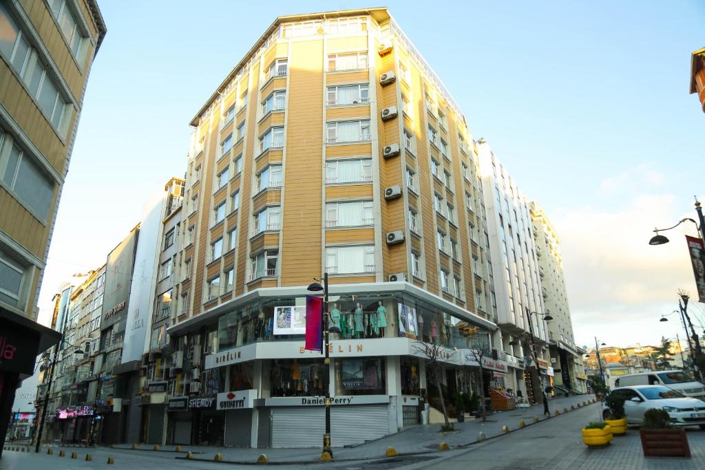 イスタンブールにあるSahinler Hotelの車の通り沿いの高い黄色の建物