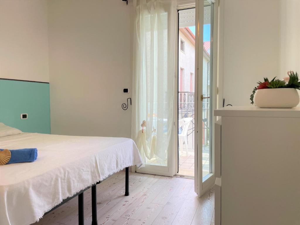 een slaapkamer met een bed en een glazen schuifdeur bij PRESTIGE - Premium Villas in Giulianova