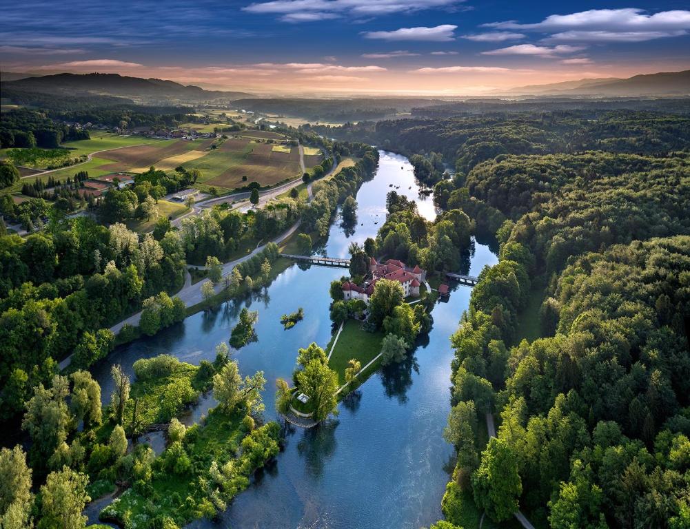 una vista aerea di un fiume alberato di Hotel Grad Otočec - Relais Chateaux a Otočec