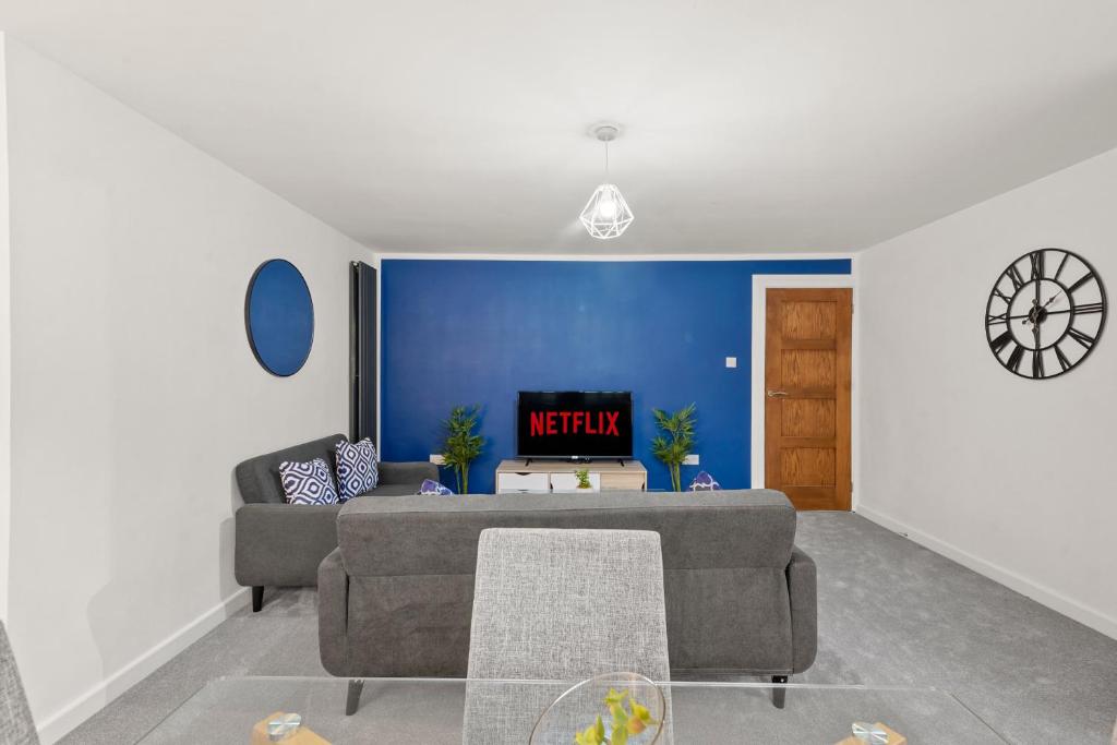 a living room with a couch and a blue wall at 2BR Barnet Gem with Front Garden in Barnet