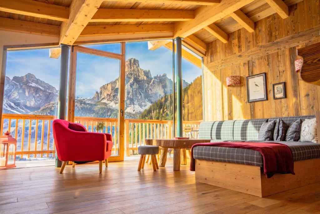 a bedroom with a large window with a mountain view at Luxury Chalet Liosa - Ski in Ski out - Amazing view in Corvara in Badia