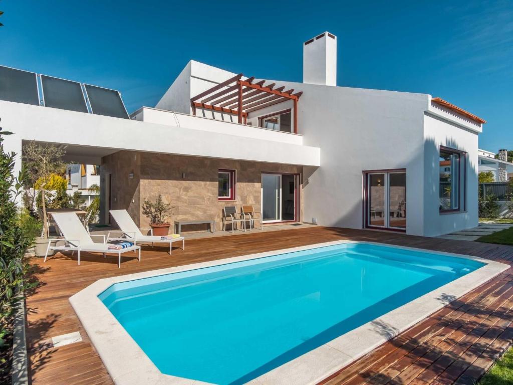 a villa with a swimming pool in front of a house at LV Premier LA2 pool, AC, garden, sea view in Lagoa de Albufeira