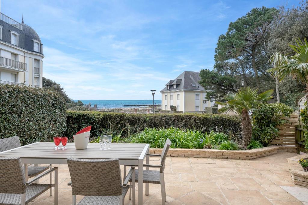 a patio with a table and chairs and the ocean at Appartement face mer pour 4 personnes in Pornic