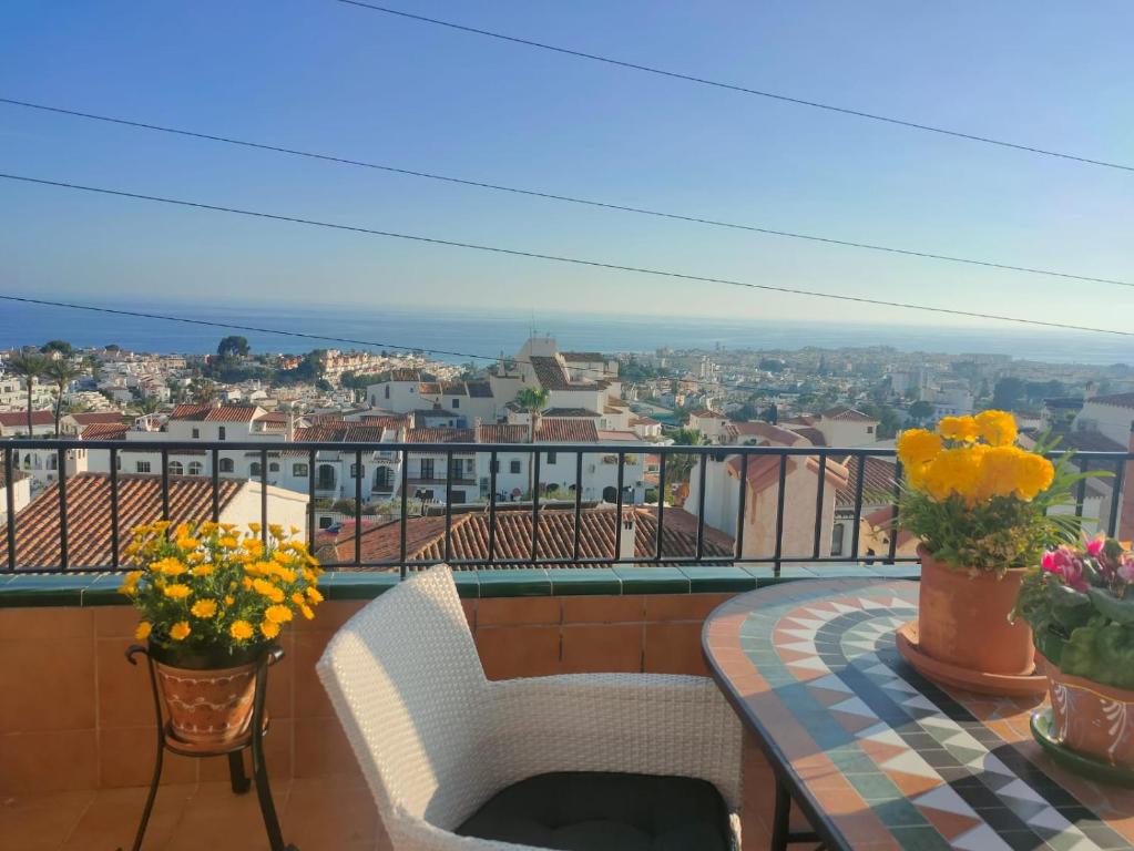 een balkon met een tafel, stoelen en bloemen bij Casa Bonita Vista Spainsunrentals 1059 in Nerja