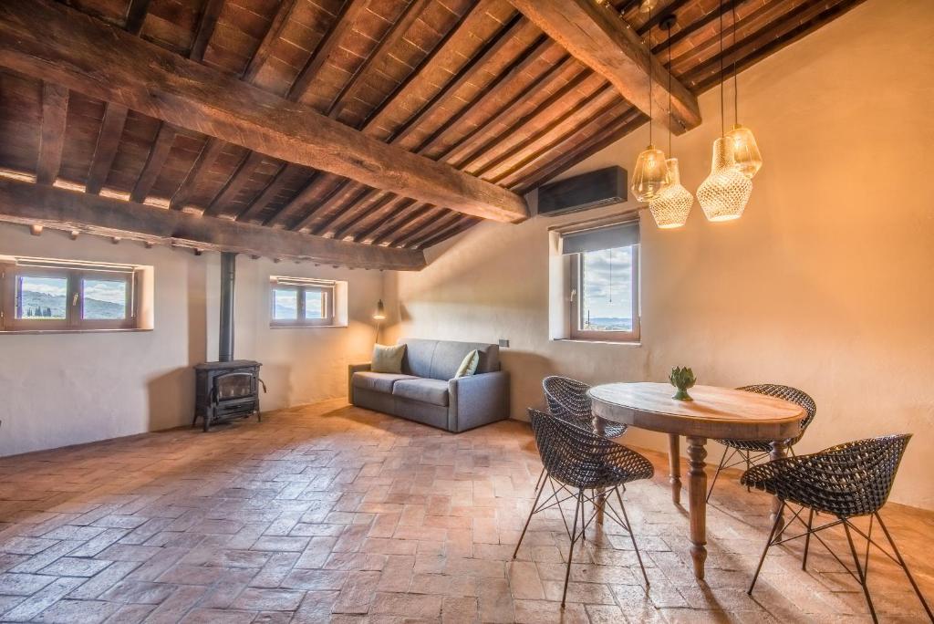 een woonkamer met een tafel en stoelen en een bank bij La Porticina in Montalcino