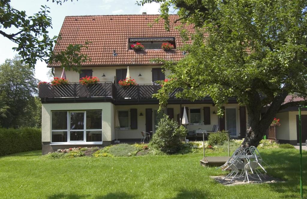 a house with a tree in the yard at Gästehaus Mäder in Bad Dürrheim