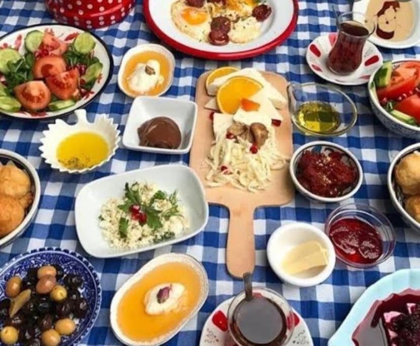 una mesa con platos de comida en un mantel azul y blanco en Please Don't Do it rezervasyon, en Kars