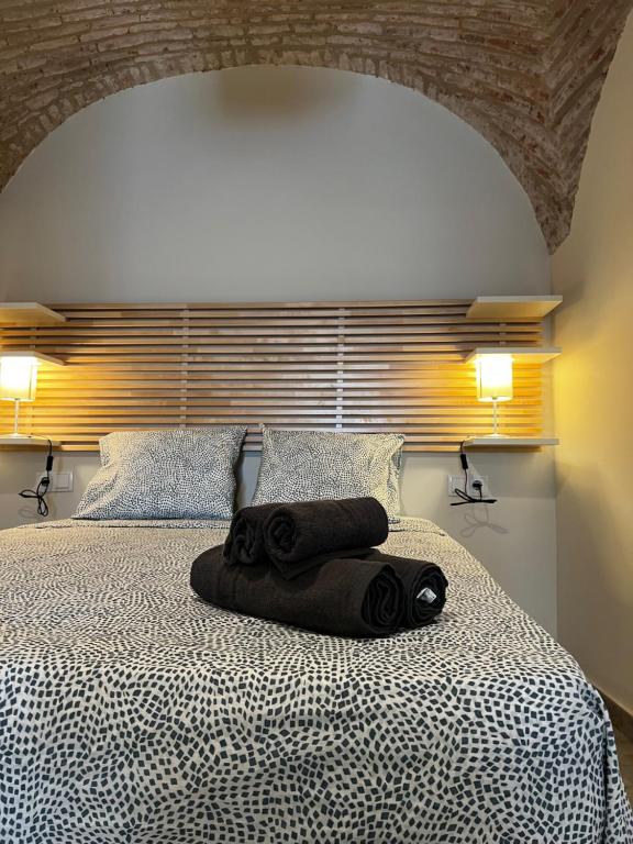 Una cama con una toalla negra encima. en Consolación17, en Cáceres