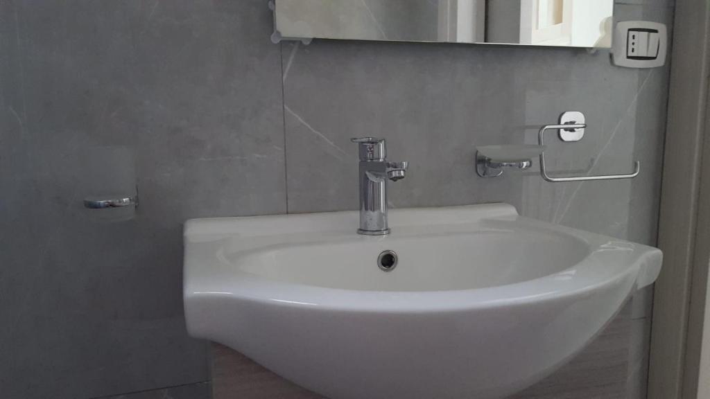 een witte wastafel in een badkamer met een spiegel bij Casa Athena in Crotone