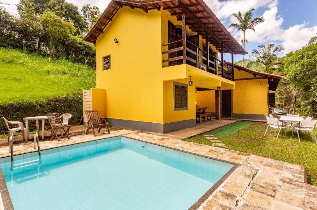 uma casa com piscina em frente a uma casa em Sítio Borges em Petrópolis