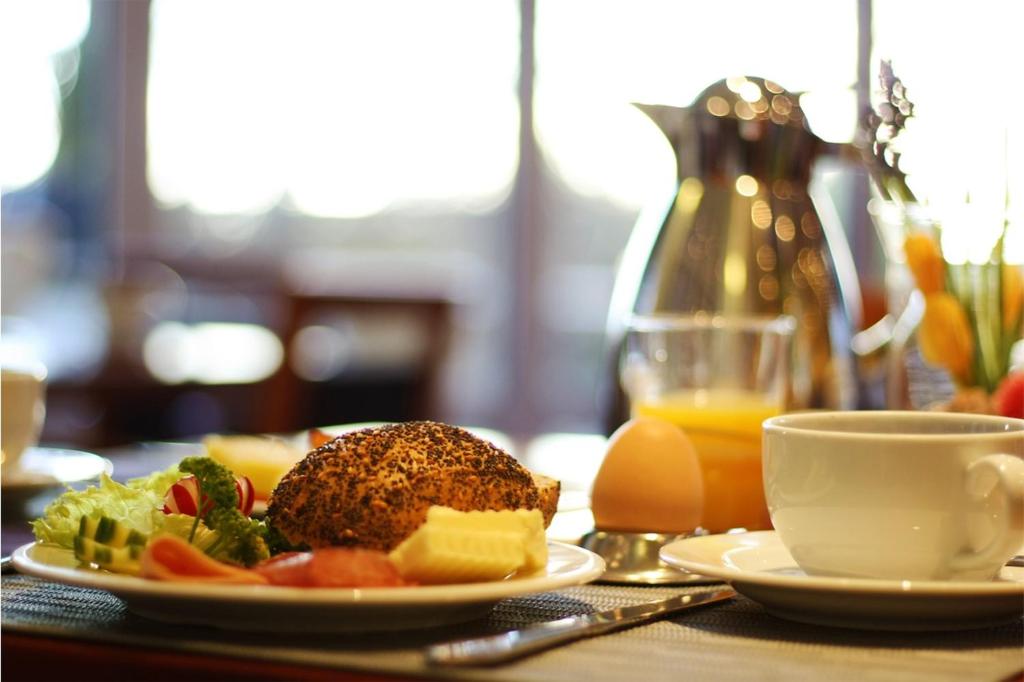 a table with plates of food and a cup of orange juice at Arkona Strandresidenzen in Binz