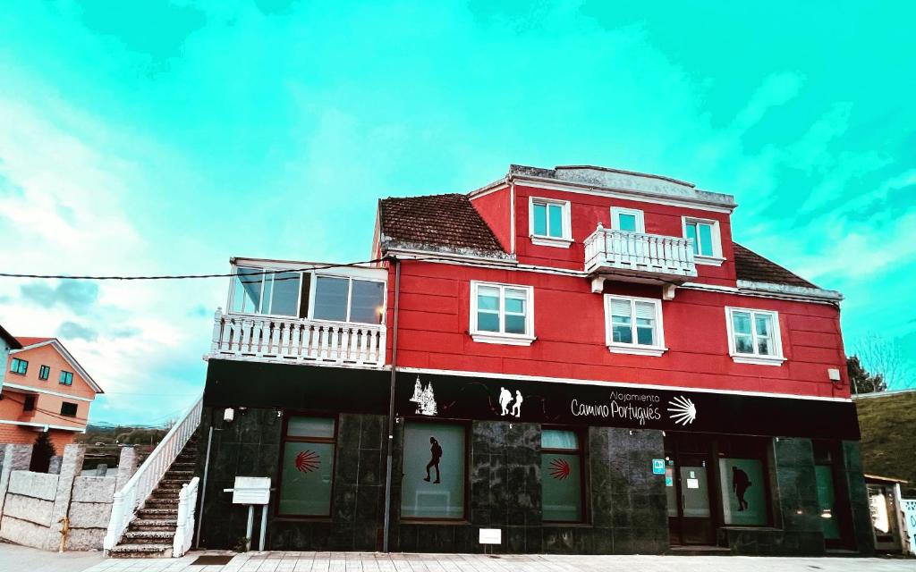 a red building with a balcony on the side of it at Alojamiento Camino Portugues in Porriño