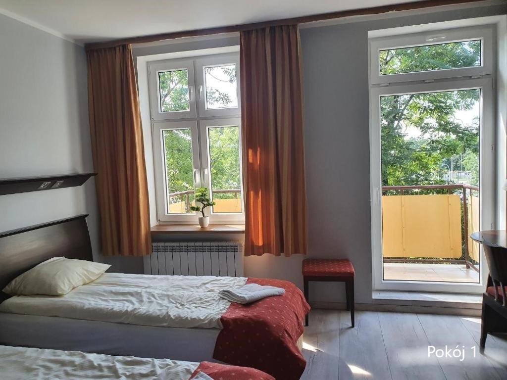 um quarto com uma cama e duas janelas em GLIWICKA 16 em Katowice
