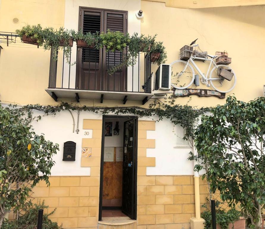 una bicicleta en el lateral de una casa con balcón en Bahalara Alloggio, en Palermo