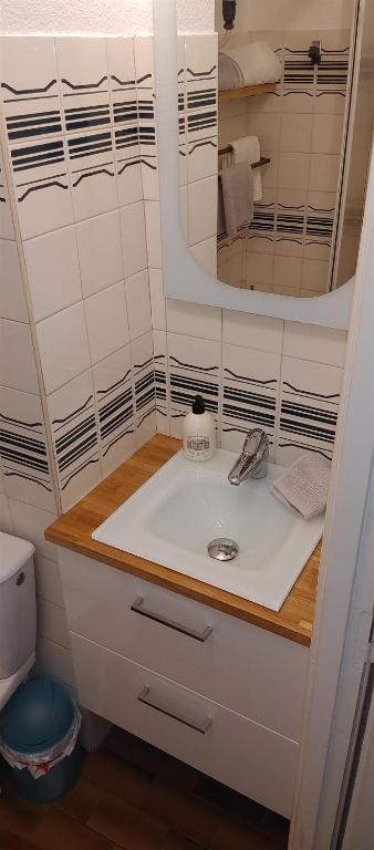 łazienka z umywalką i lustrem w obiekcie Appartement double avec chambre séparée - Village naturiste Héliopolis Cap d'Agde w Cap d'Agde