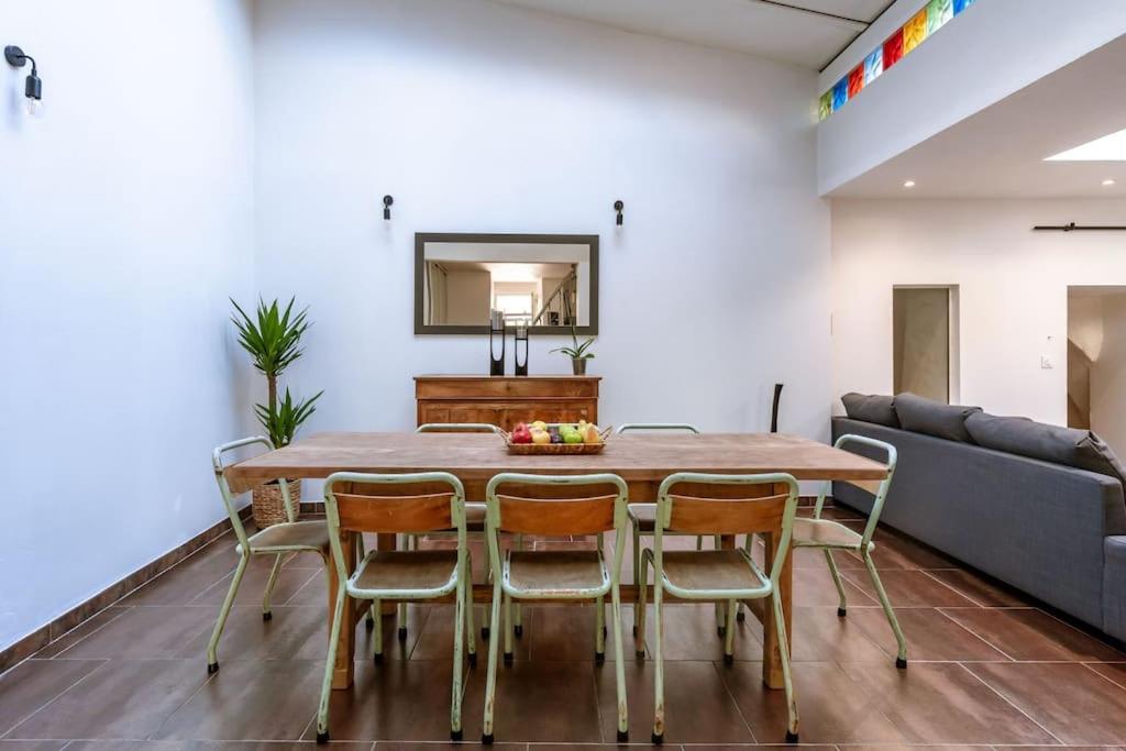 une salle à manger avec une table, des chaises et un canapé dans l'établissement Lou Roucas : Agréable maison de village avec vue, à Fontaine-de-Vaucluse