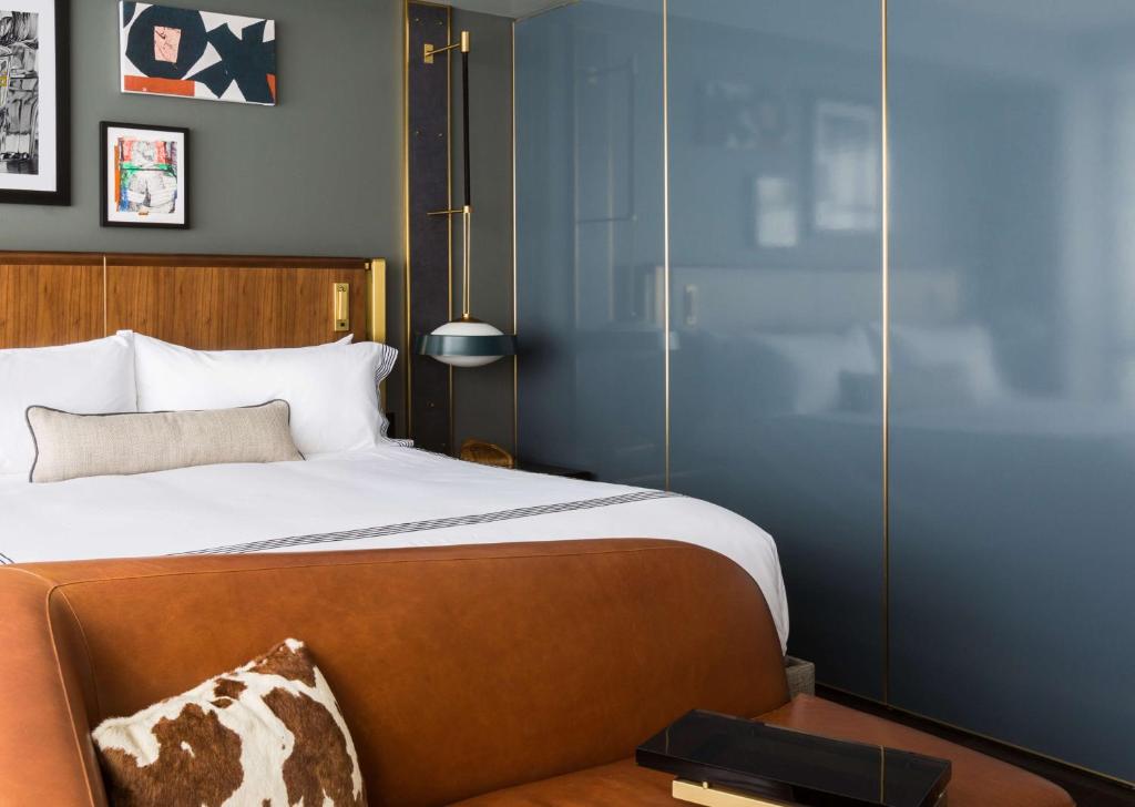 a bedroom with a large bed with a wooden headboard at Thompson Dallas, by Hyatt in Dallas