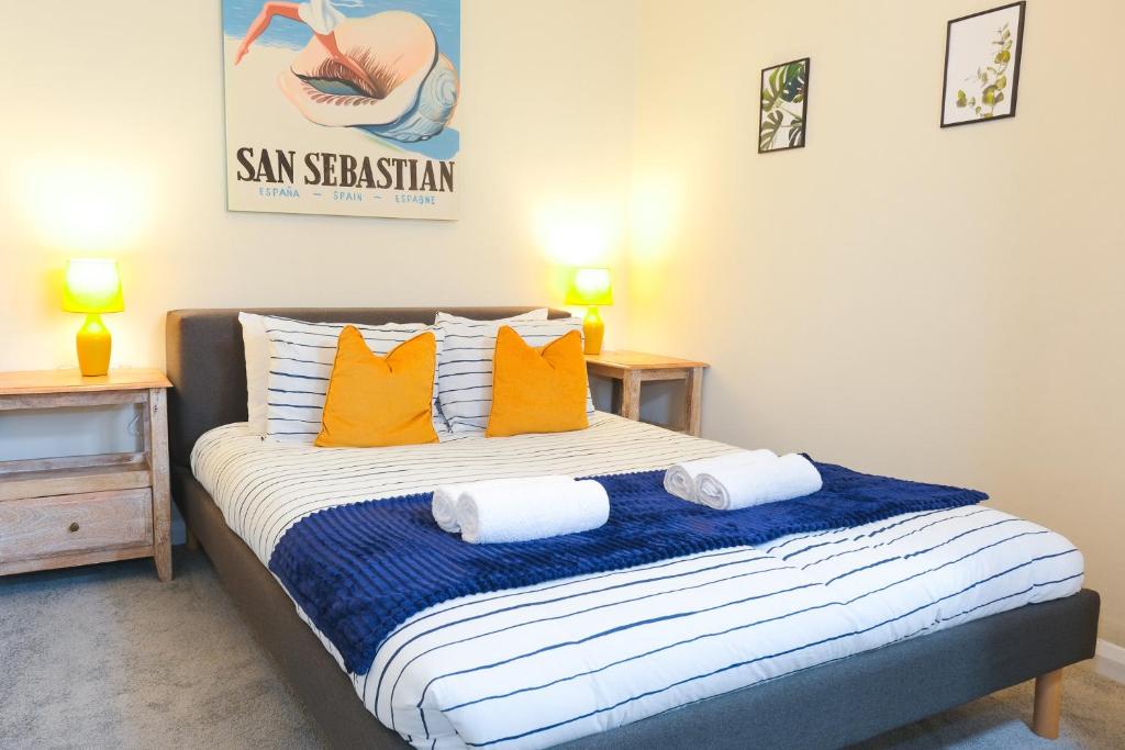 a bedroom with a bed with orange and white pillows at Spacious Apartment -Double and Sofabed -Wonderful Royal Pavilion Views in Brighton & Hove