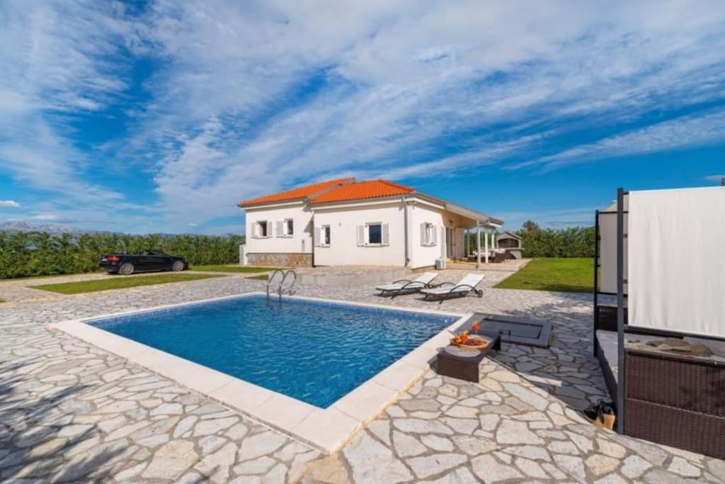 uma villa com uma piscina e uma casa em Fairyland Villa 150qm für 8pax em Paljuv
