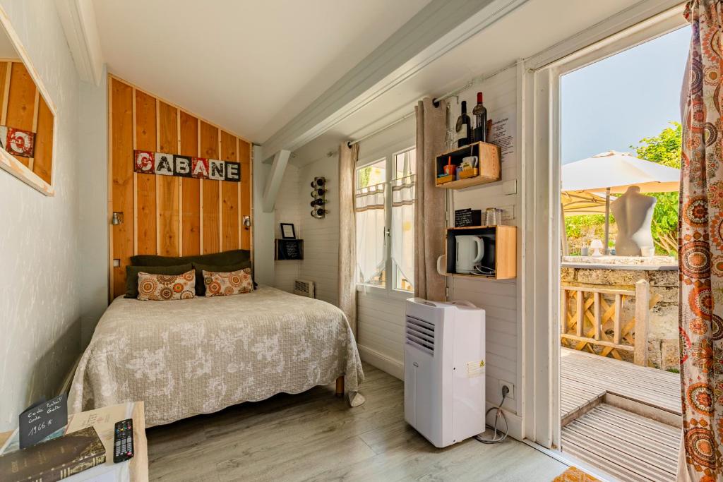 um quarto com uma cama e uma grande janela em Les Chambres d'Ovaline em Saint-Émilion