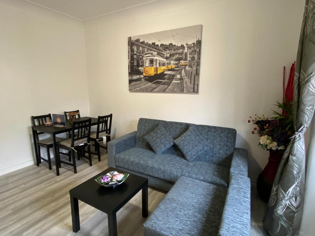 リスボンにあるMaiur Apartmentのリビングルーム(青いソファ、テーブル付)