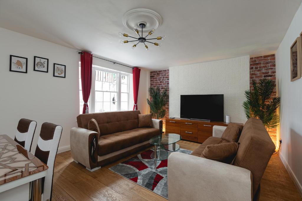ein Wohnzimmer mit einem Sofa und einem TV in der Unterkunft 2 bed 2 bath APT Central London in London