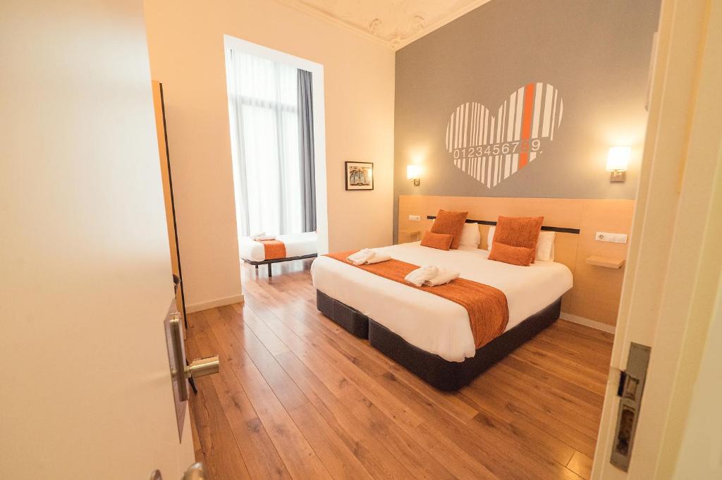 1 dormitorio con 1 cama y un corazón en la pared en Hostal Live Natura Barcelona, en Barcelona