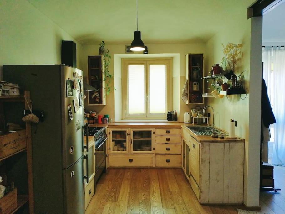 een keuken met een koelkast, houten vloeren en een raam bij Intero appartamento zona centrale in Turijn