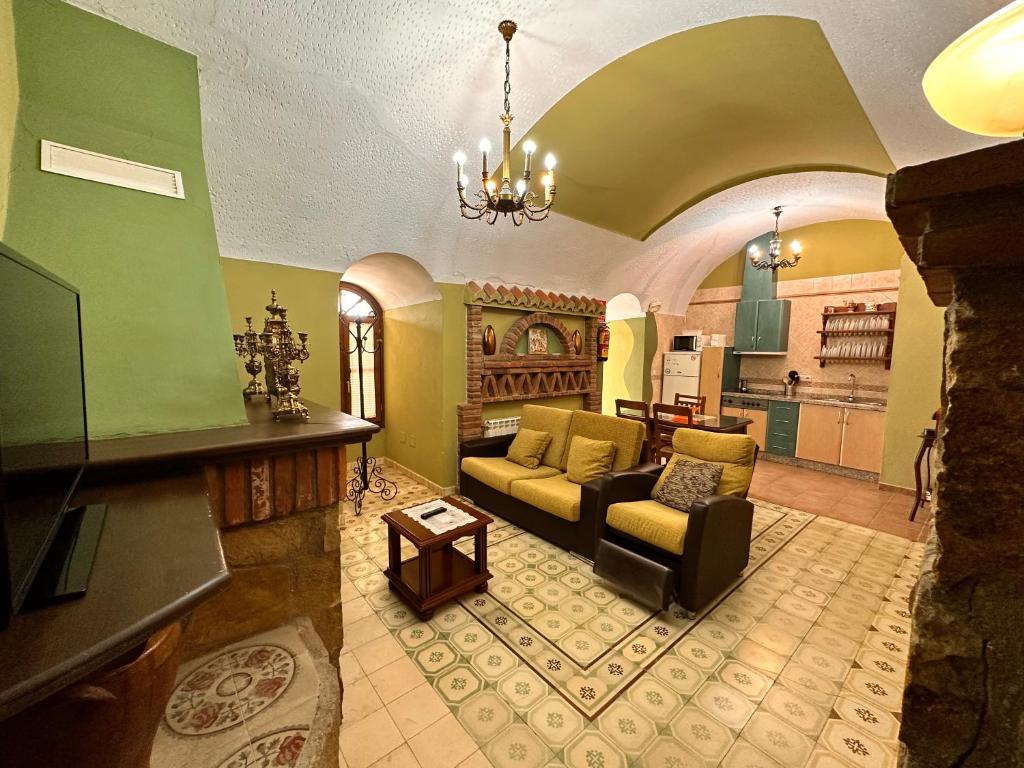 Una sala de estar con un sofá y una cocina. en Cuevas La Granja, en Benalúa de Guadix