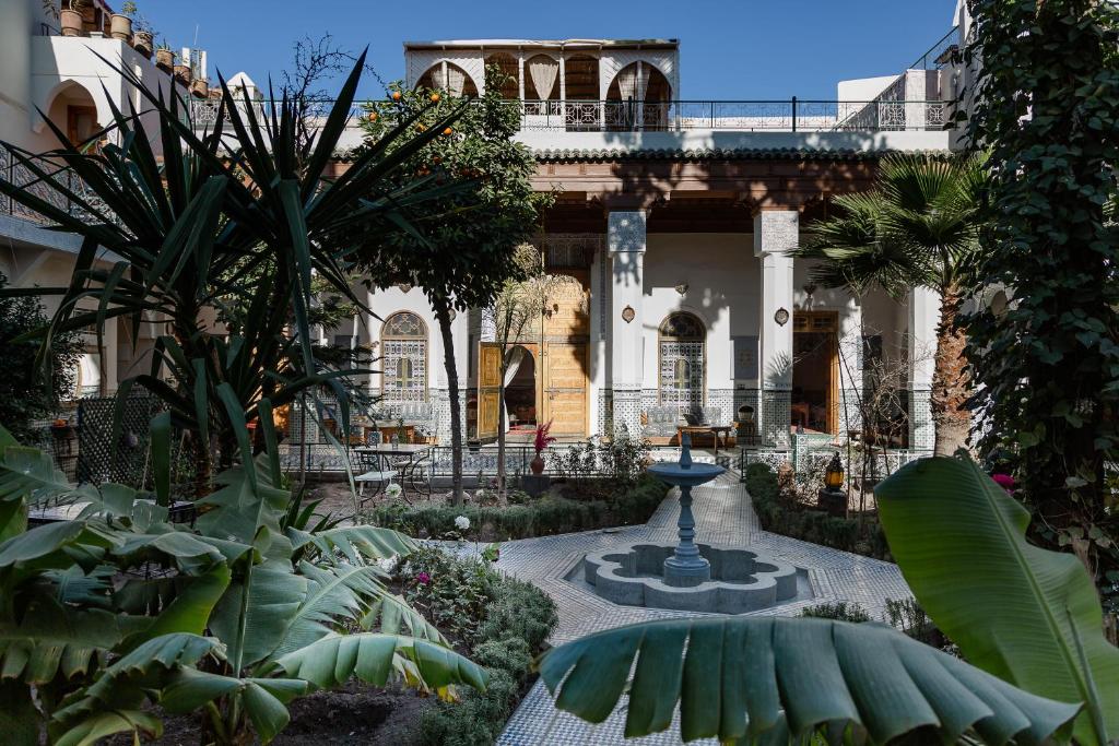 a courtyard with a fountain in front of a building at Riad 4 jardins in Marrakesh