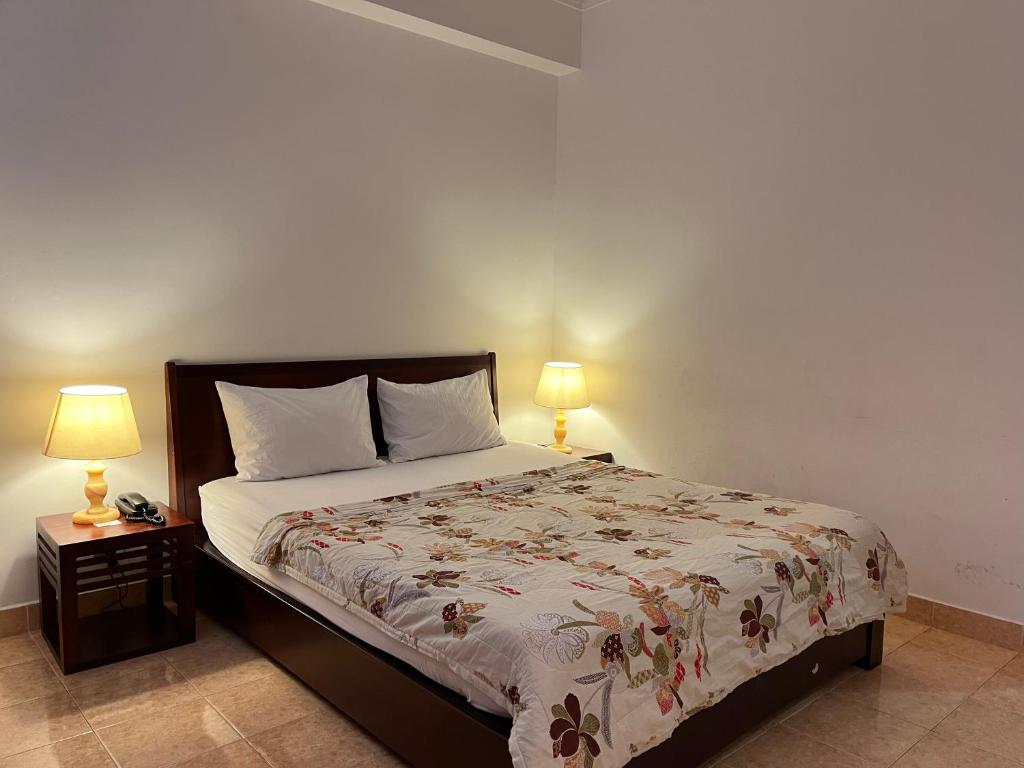 1 dormitorio con 1 cama y 2 lámparas en las mesas en Phung Long Hotel, en Ho Chi Minh