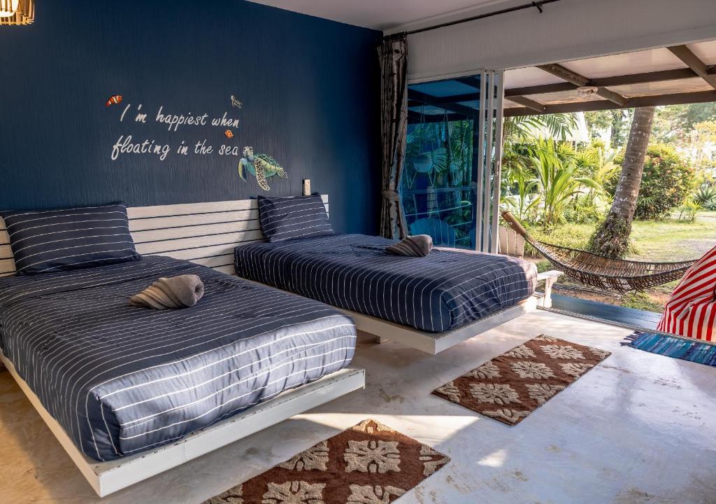 two beds sitting next to each other in a bedroom at Baan Koh Mak in Ko Mak