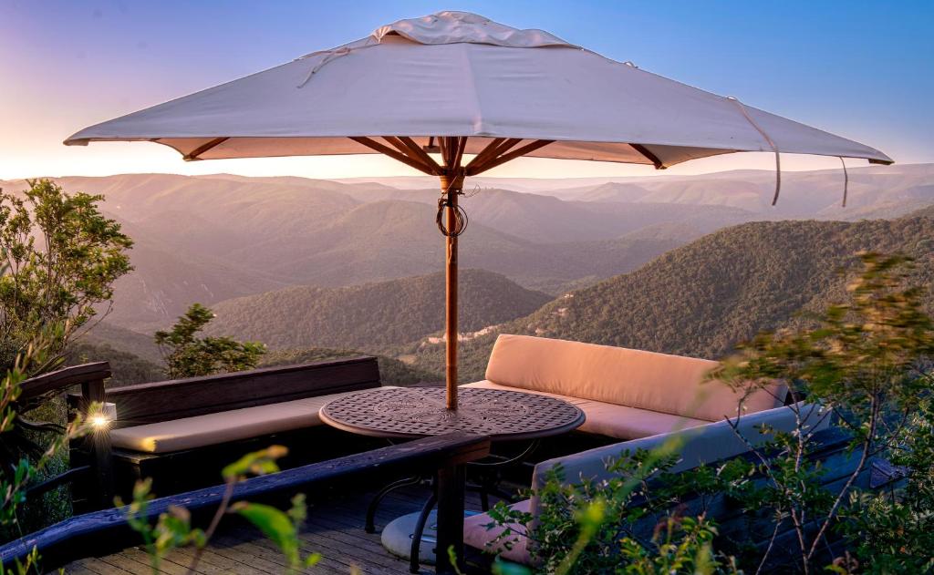 a table with an umbrella on top of a mountain at Camp Figtree by The Oyster Collection in Addo