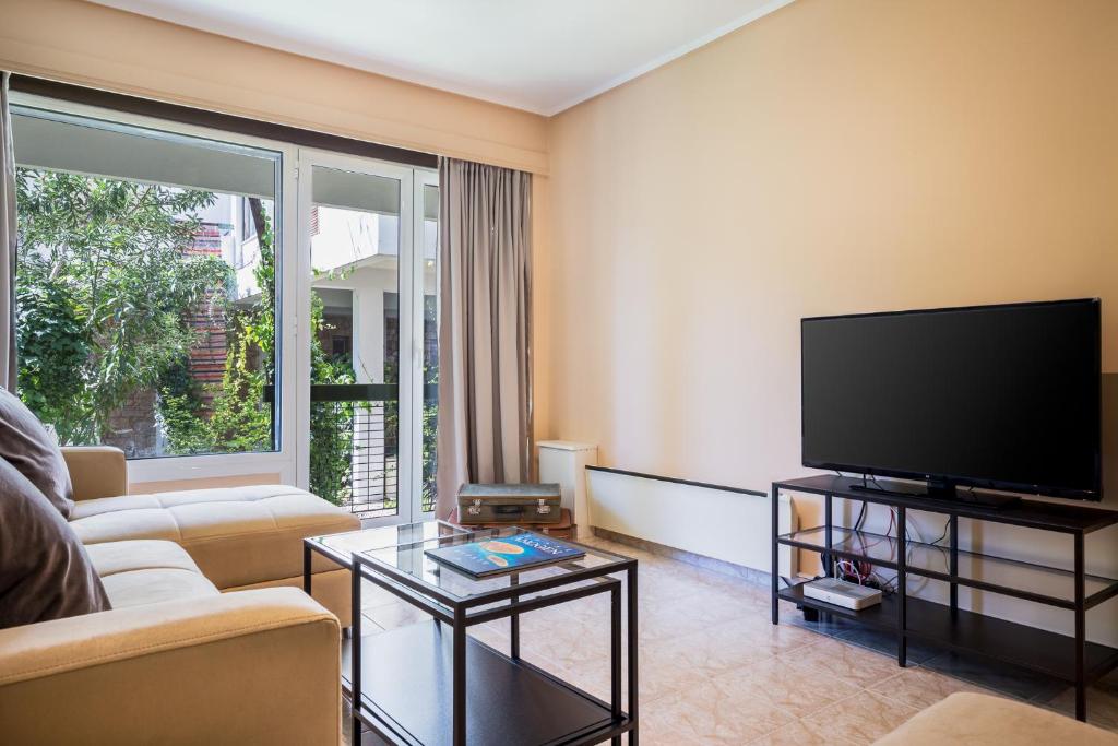 uma sala de estar com um sofá e uma televisão de ecrã plano em Glyfada 2 bedrooms 4 persons apartment by MPS em Atenas