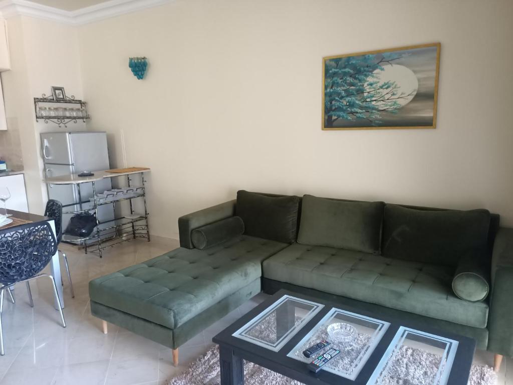 sala de estar con sofá verde y mesa en EL MANZEl 102 en Houmt El Souk