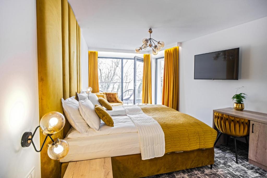 a bedroom with a large bed with yellow curtains at Cristal Baltic in Ustka