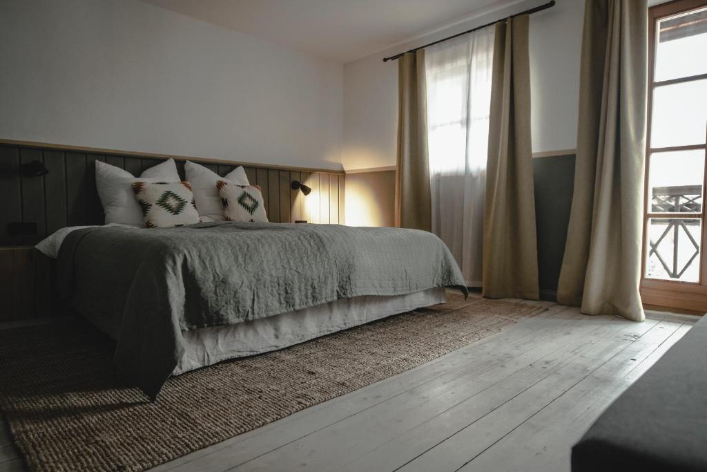 - une chambre avec un lit doté d'oreillers et d'une fenêtre dans l'établissement Kastanienhof Pfettrach, à Altdorf