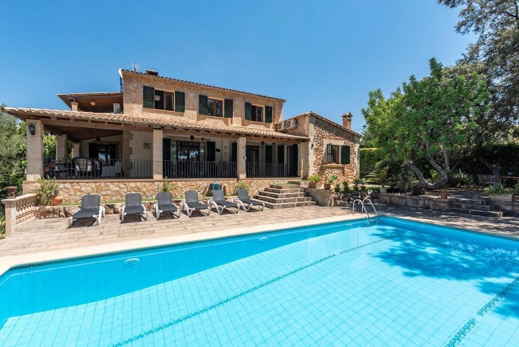 une villa avec piscine devant une maison dans l'établissement S'alzinaret, lujosa Villa con piscina, à Bunyola